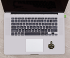 Laptop with a sticker on the trackpad on a wooden surface