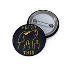 Glossy black pinback button with gold outline of angry dog giving double middle fingers and text “FETCH THIS.”