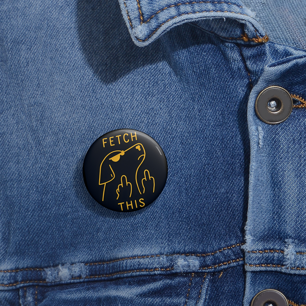 Denim jacket with a glossy black pinback button with gold outline of angry dog giving double middle fingers and text “FETCH THIS.”