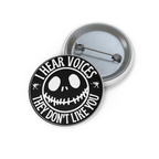 Black and white button with creepy smiley face and text “I Hear Voices, They Don’t Like You.” Glossy finish, metal backing.