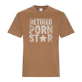 Caramel colored graphic T-shirt featuring large distressed white block lettering reading “Retired Porn Star,” with a white star replacing the letter A in “Star” for a bold vintage-style design.